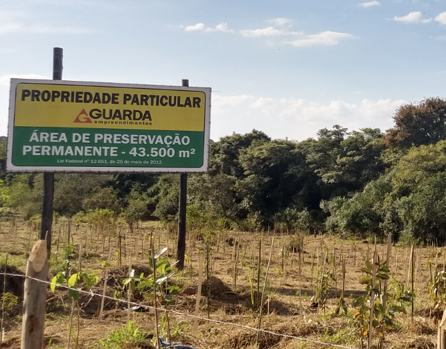 Terreno com placa indicando área de preservação permanente